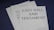 A stack of documents on a dark surface, with the top page clearly labeled 'Last Will and Testament' in bold letters. The documents appear to be legal papers, suggesting importance and formality.