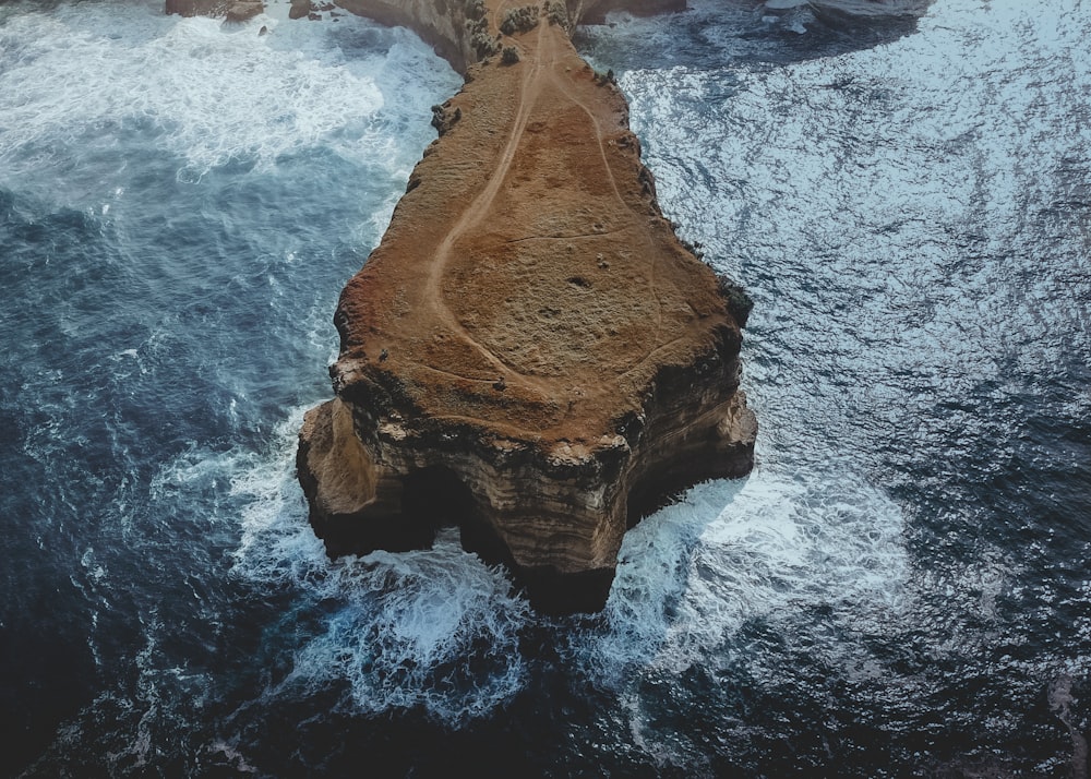 Montaña rocosa marrón al lado del cuerpo de agua