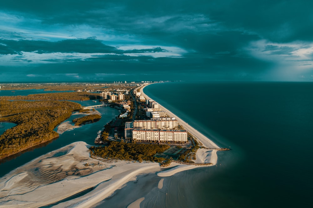 aerial photography of white house beside ocean under gray clouds at daytime