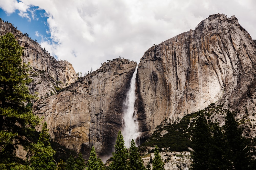 waterfalls under cloudy sky