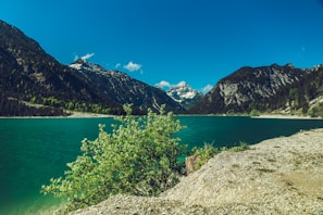 A serene landscape featuring a tranquil lake surrounded by mountains.