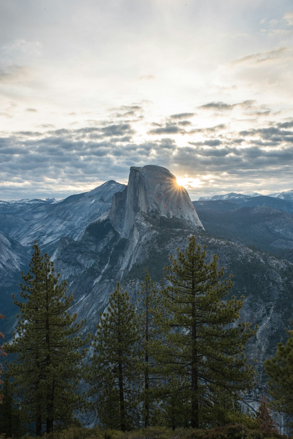 sun rising over mountain under cloudy sky