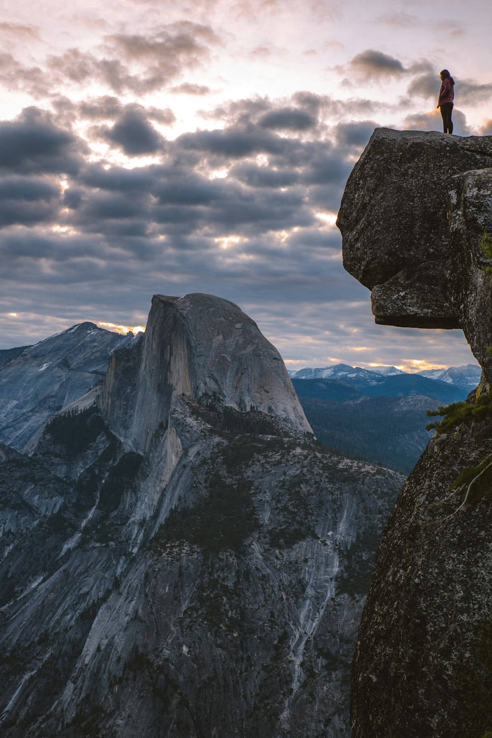 person standing on rocky mountain cliff