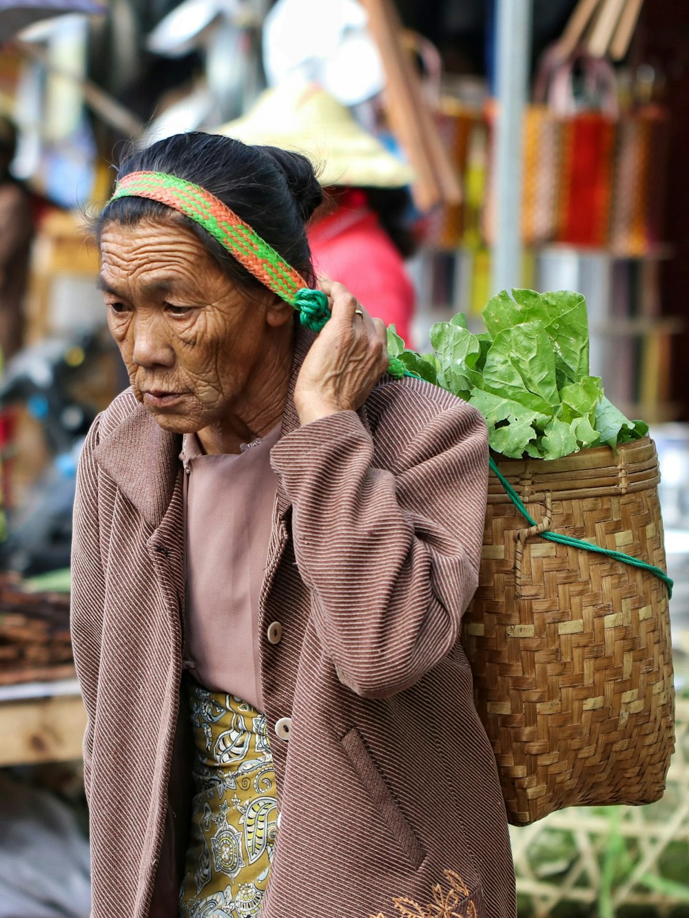 woman carrying basket with lettuce