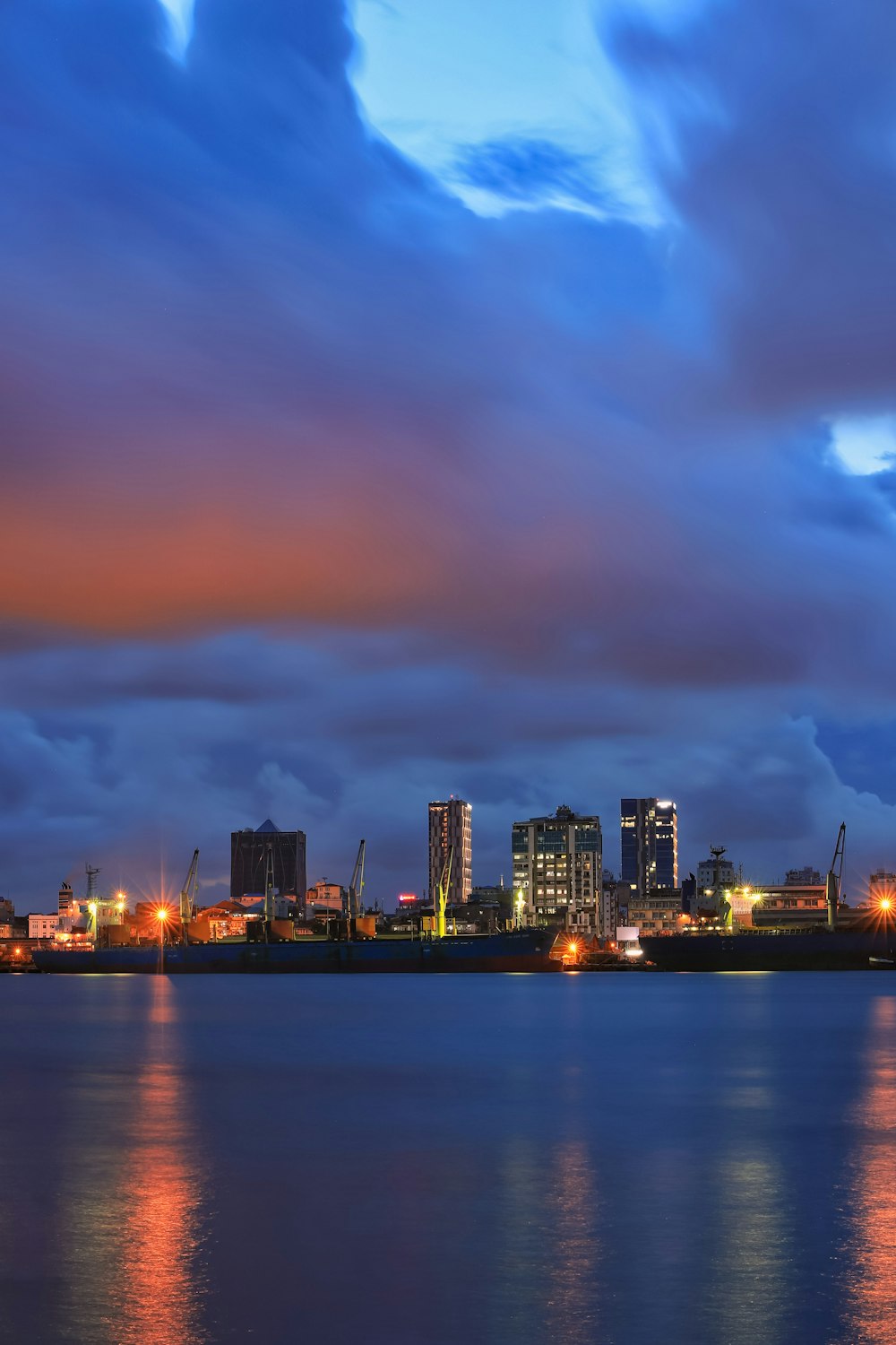 body of water near buildings at night time