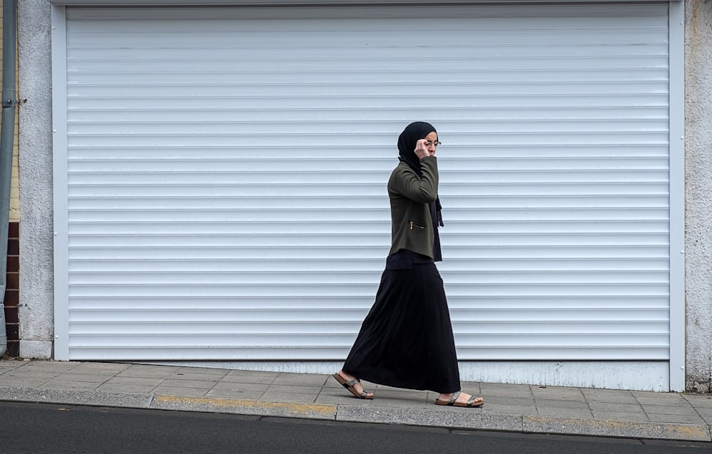 woman walking beside closed roll-up door