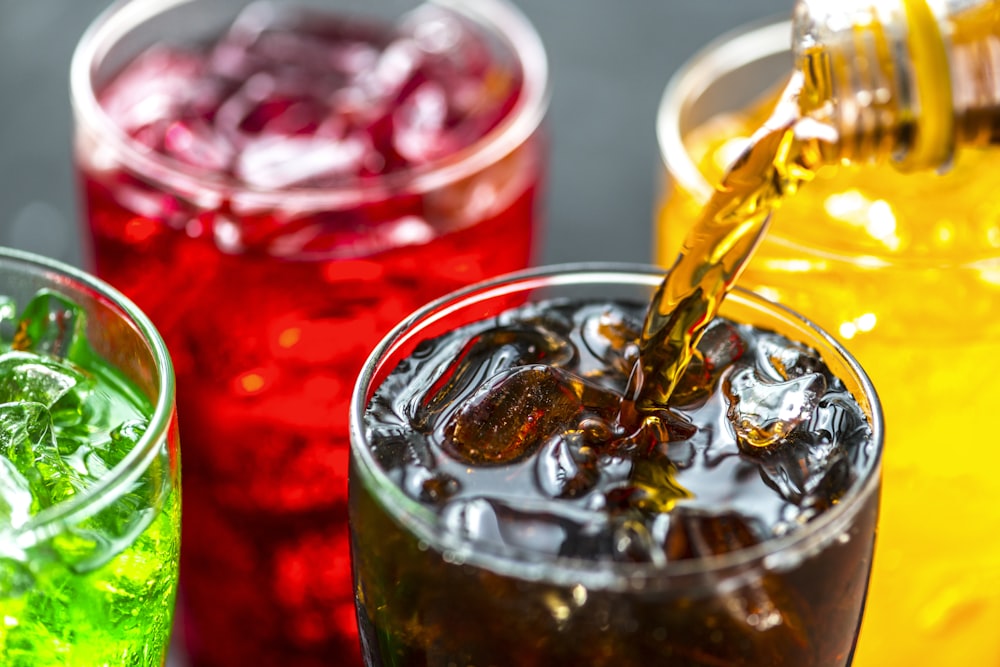 closeup photo of soda bottle pouring on glass