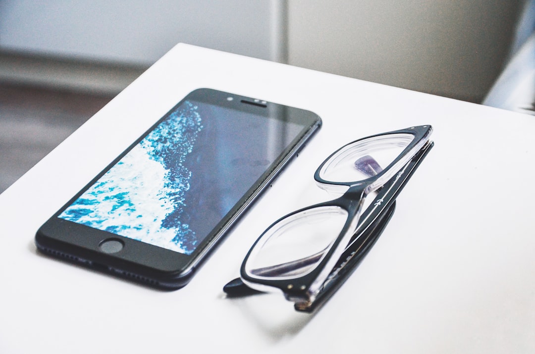 black eyeglasses near iPhone,