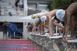 Group of trainers encouraging young swimmers in the water.