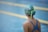girl wearing swimsuit, swim cap, and swim goggles in front of swimming pool