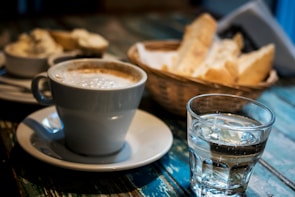 Freshly baked baguettes and cappuccino served on a rustic wooden table at a cozy sport café