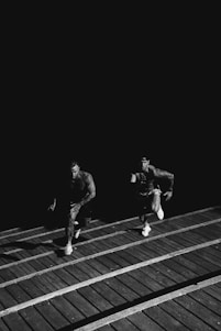 grayscale photo of two men racing each other