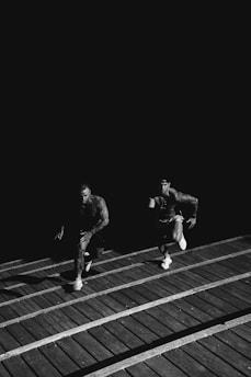 grayscale photo of two men racing each other