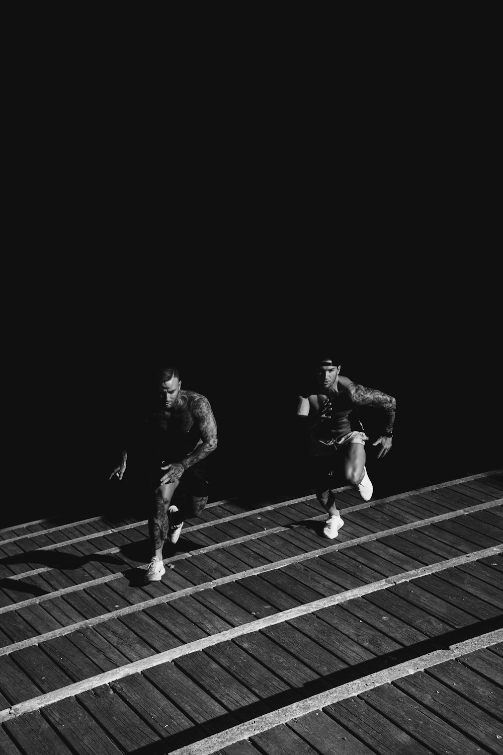 서로 경주하는 두 남자의 회색조 사진