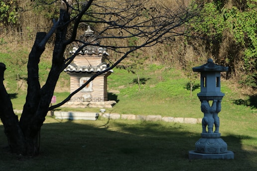A serene Zen meditation garden at sunrise with soft mist and stone lanterns.