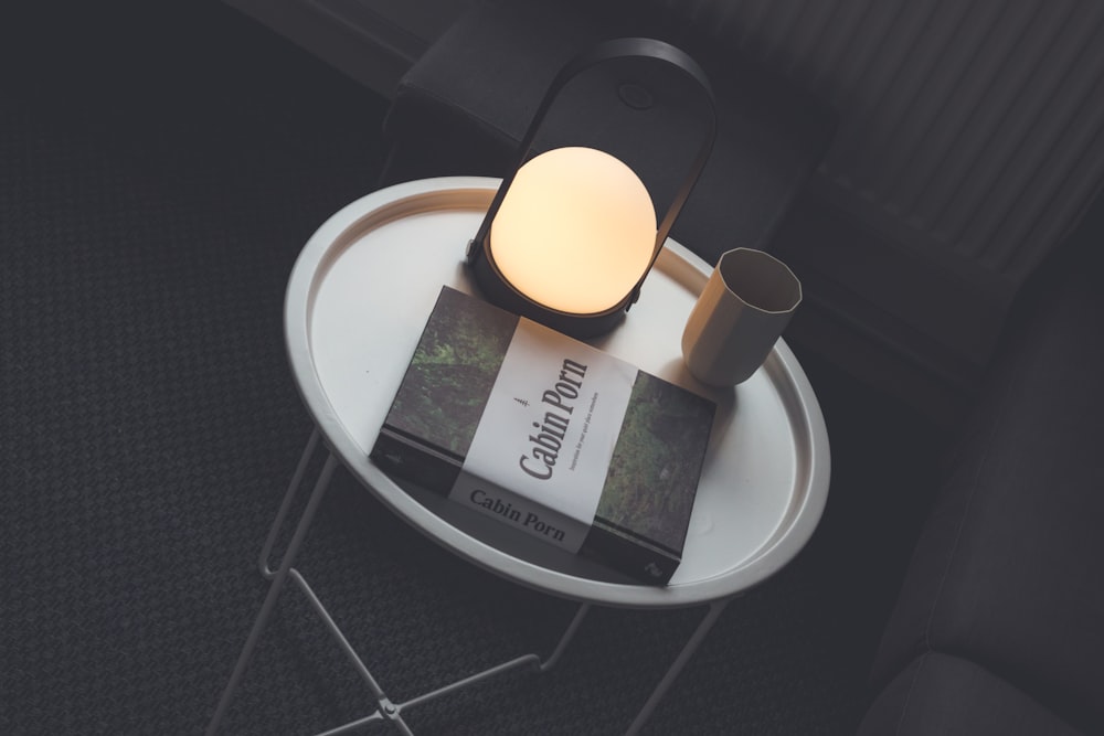 Cabin Porn book beside lamp and drinking cup on table