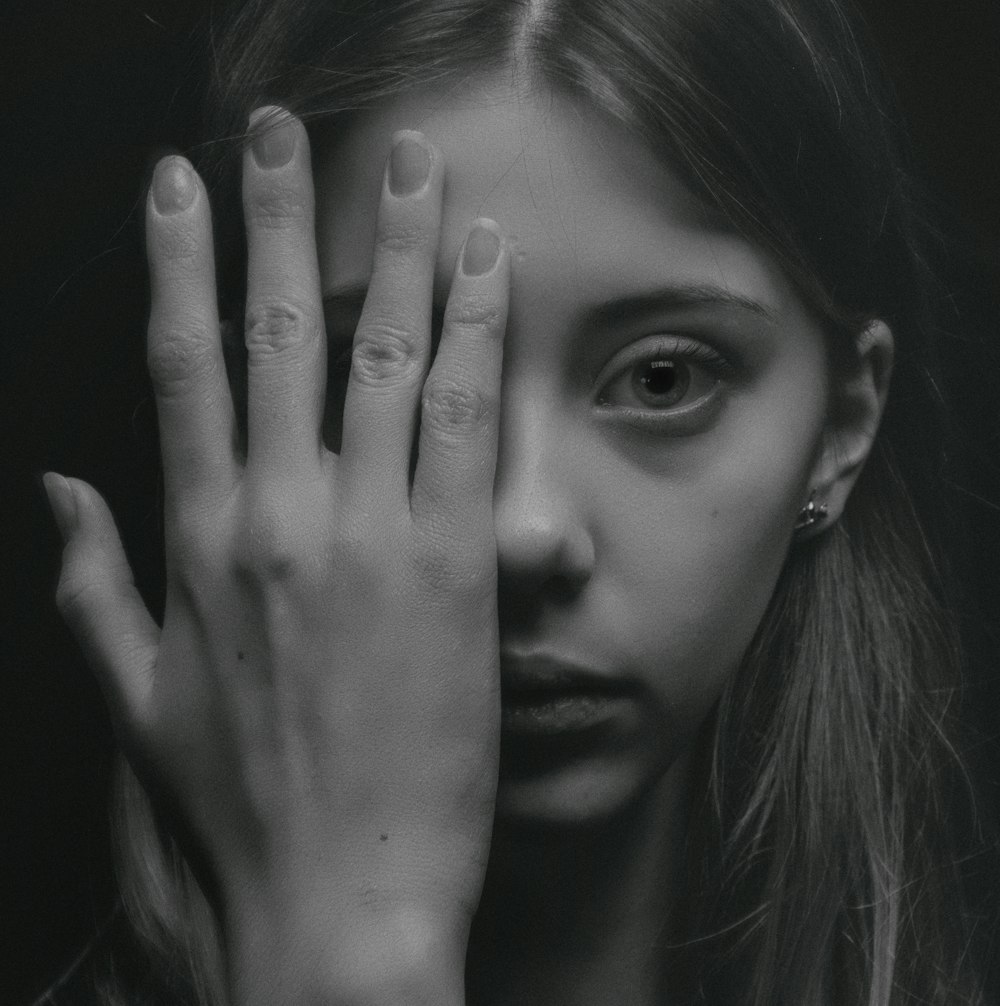 Tight cropped face of a scared young girl with hands covering