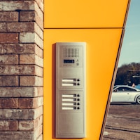 gray alarm system on yellow wall