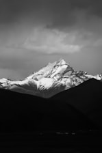 grayscale photo of mountain coated snow