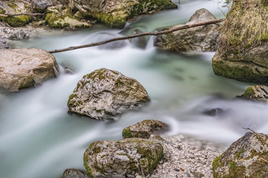 stream with moss covered rocks during daytime in Ramsauer Ache Germany