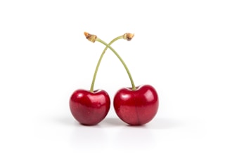 two cherries on white surface