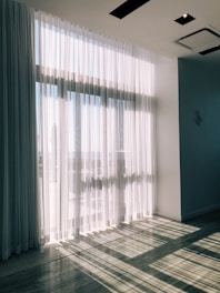 Bright hotel room with natural light streaming through sheer curtains.