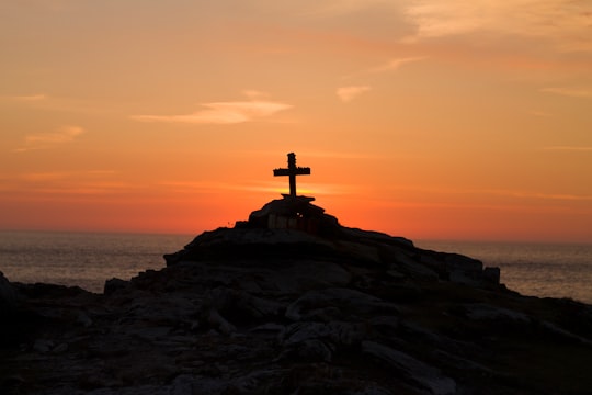 cross silhouette on mountain during golden hour in Malin Head Ireland