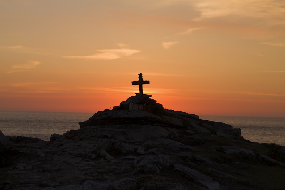 Silhouette de croix sur la montagne pendant l’heure d’or