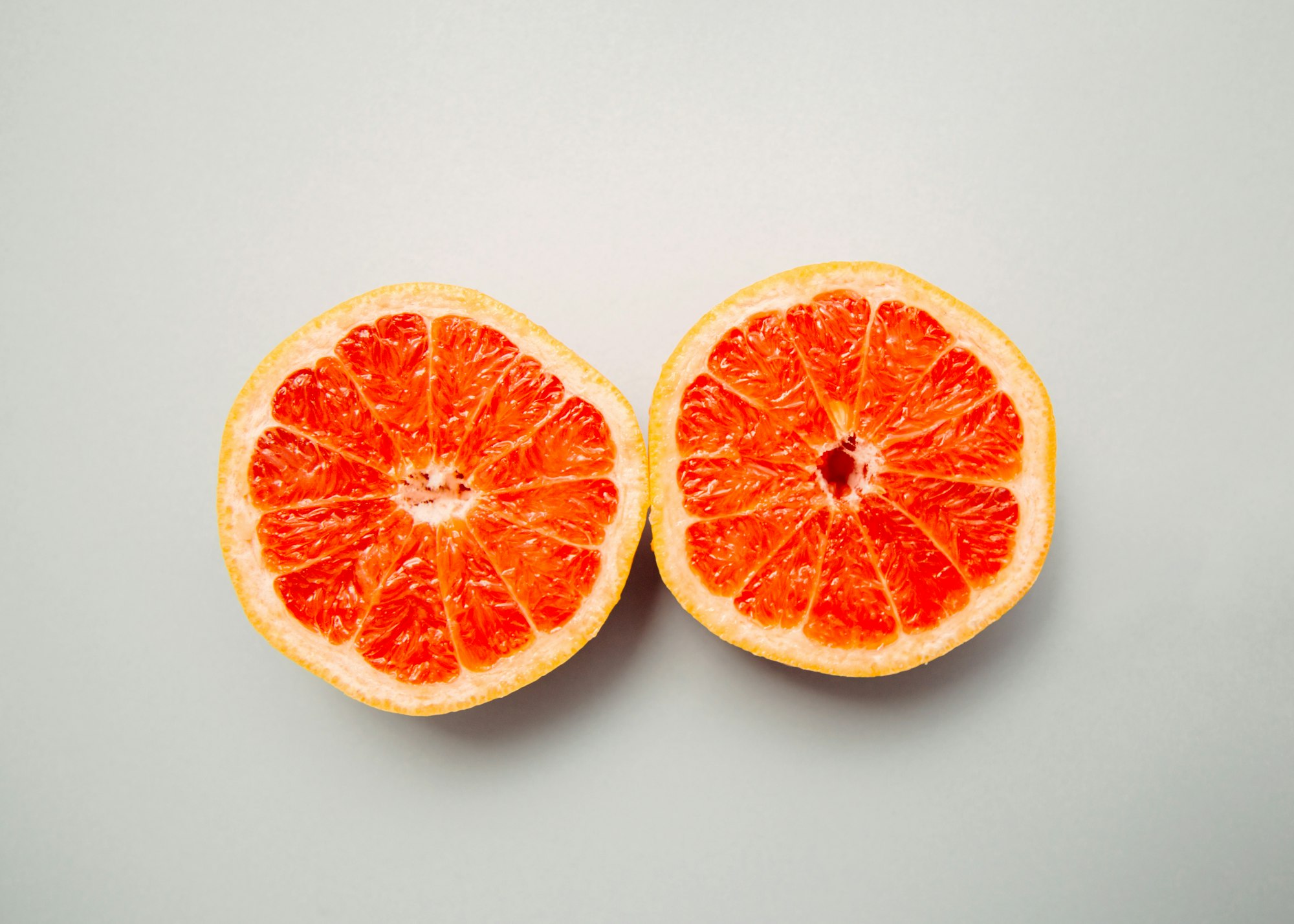 A sliced grapefruit in half resembling breasts.