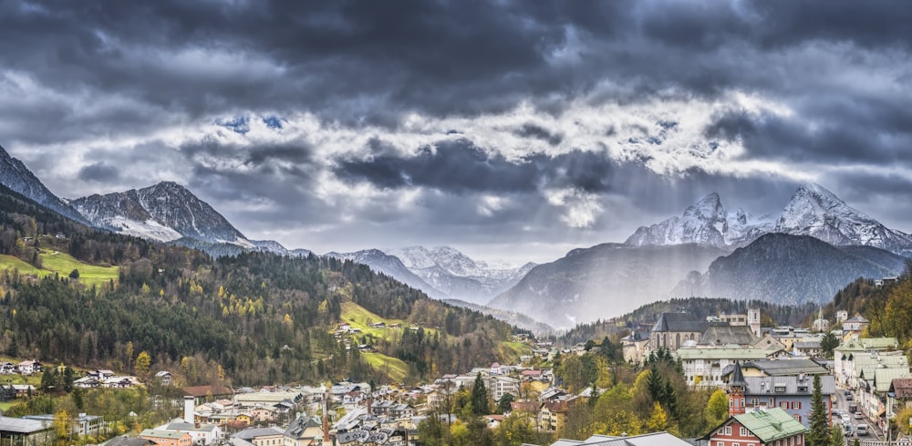 village near trees under cloudy sky at daytime