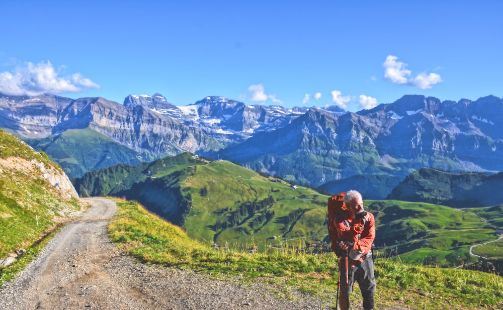 man standing far away from mountains