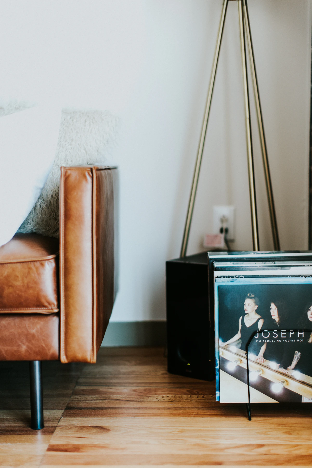 A leather sofa in a loft with a floor lamp and a record player