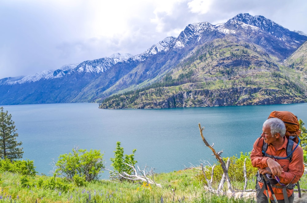 person standing overlooking mountain and lake at daytime