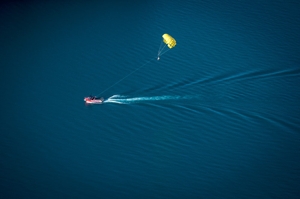 parachute near red personal water craft