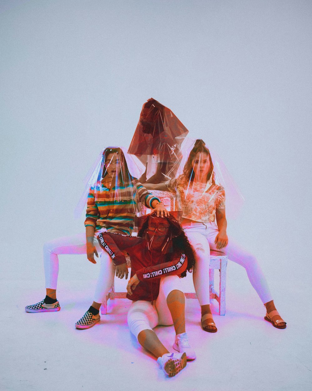 four person sitting on chair with plastic bag covering their heads