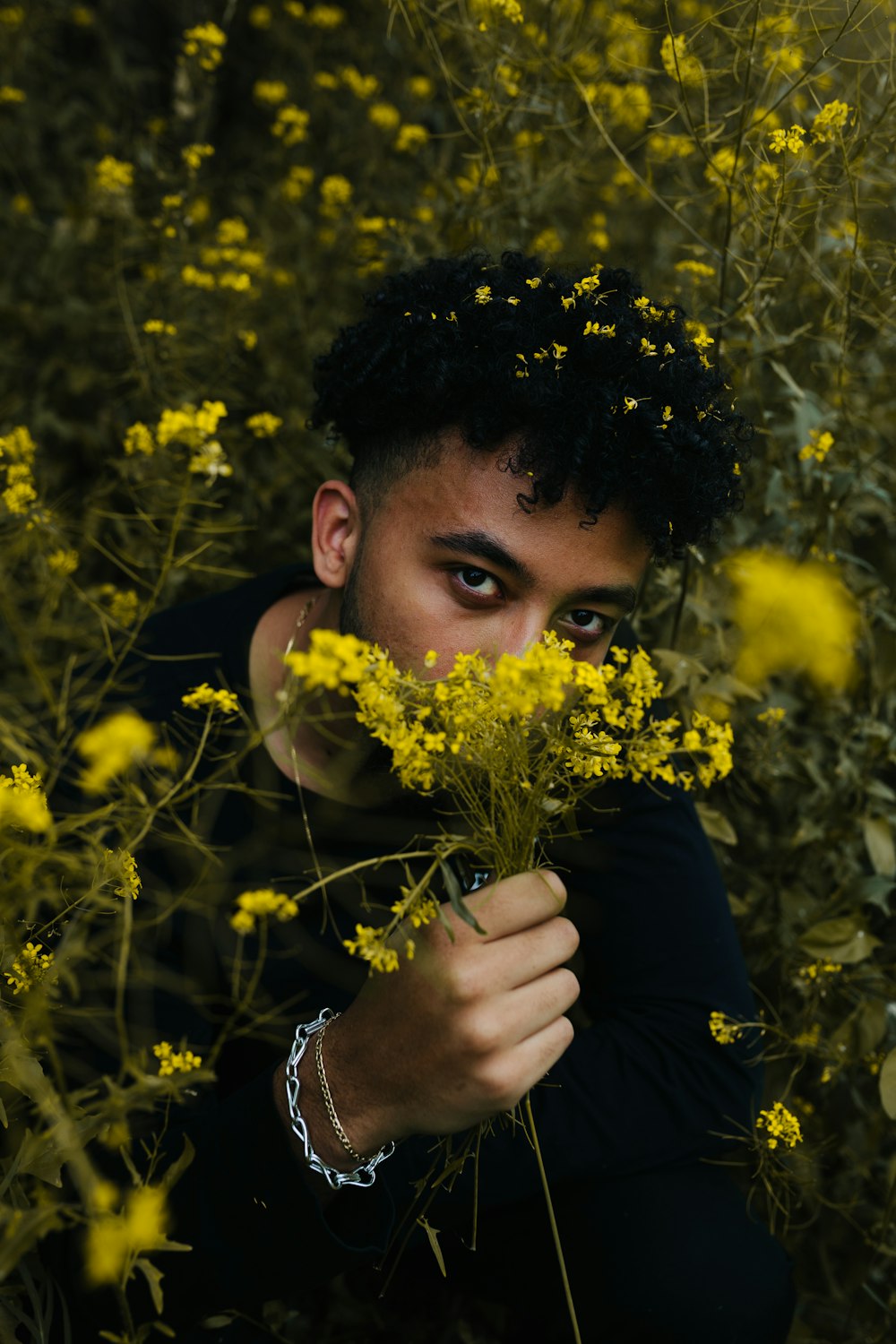 man holding yellow flowers at daytime