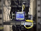 blue and grey corded electronic device on top of black device
