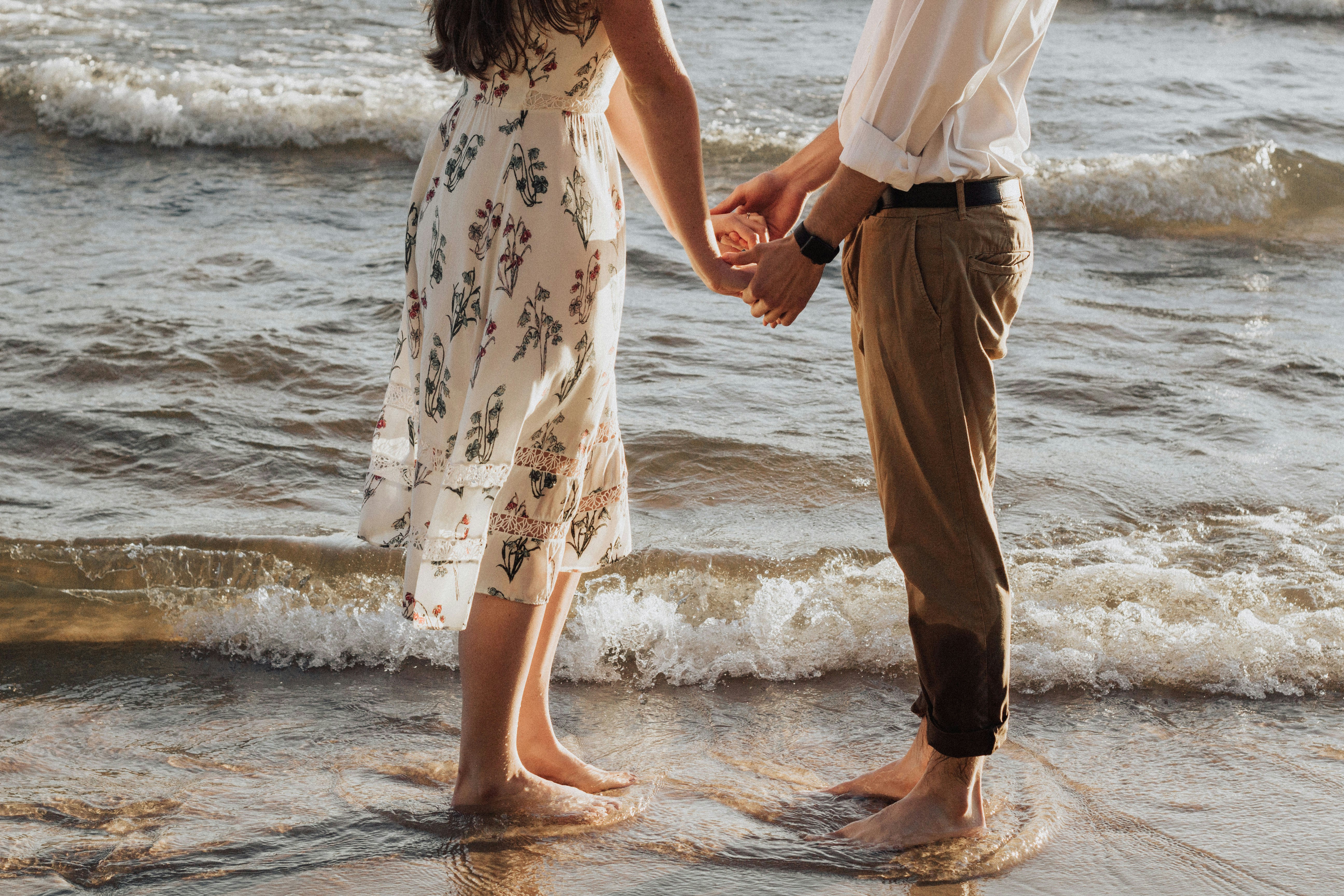 A couple holding hands in waves
