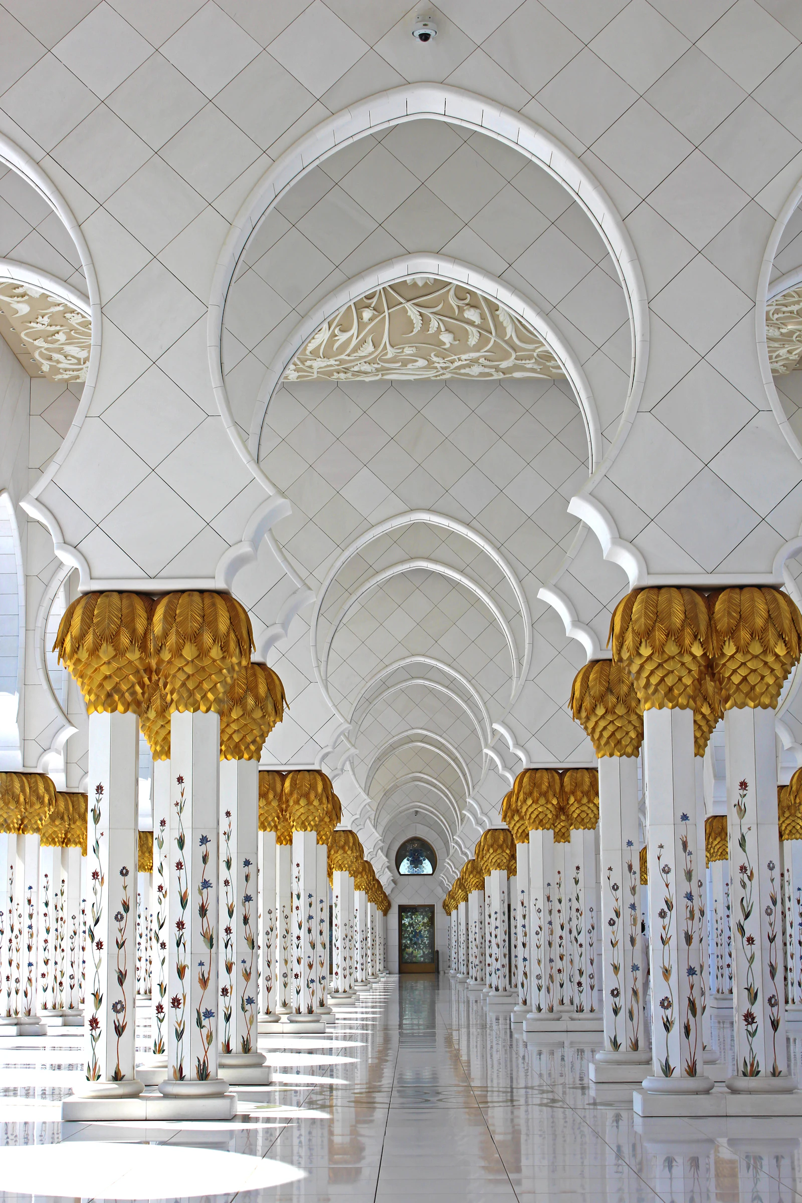 White marble arches and gilded columns inside the Sheikh Zayed Grand Mosque, Abu Dhabi.