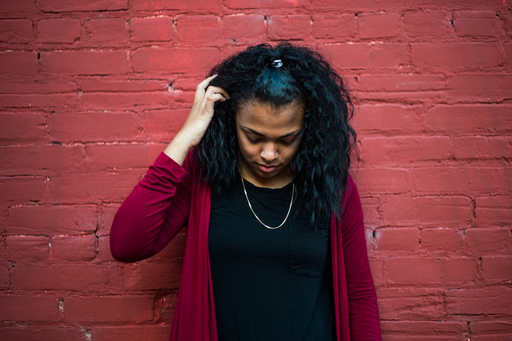 woman standing behind red wall