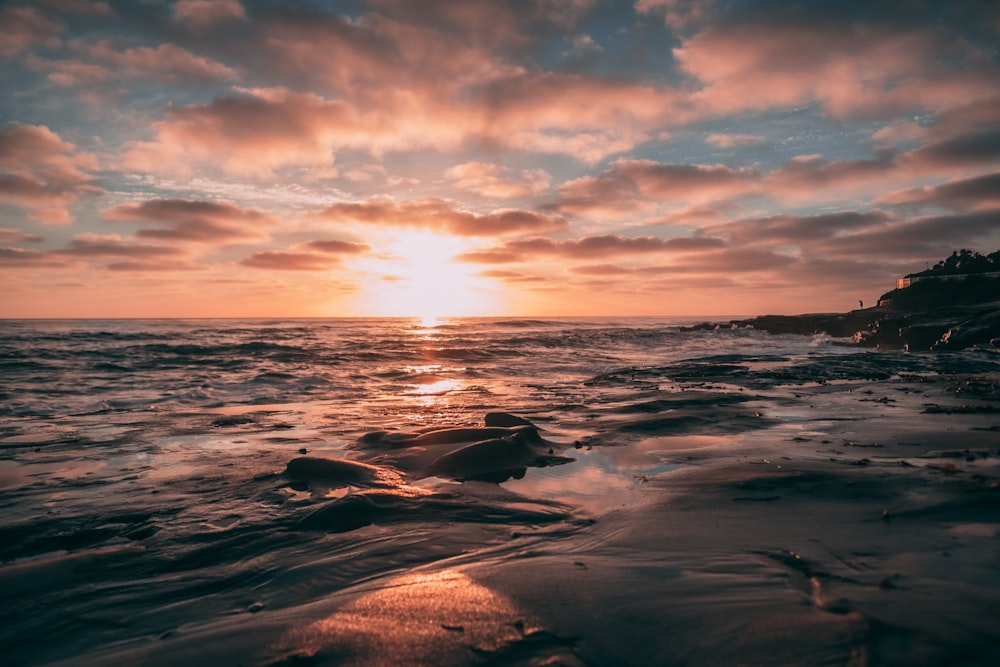 sea waves crashing on shore during golden hour