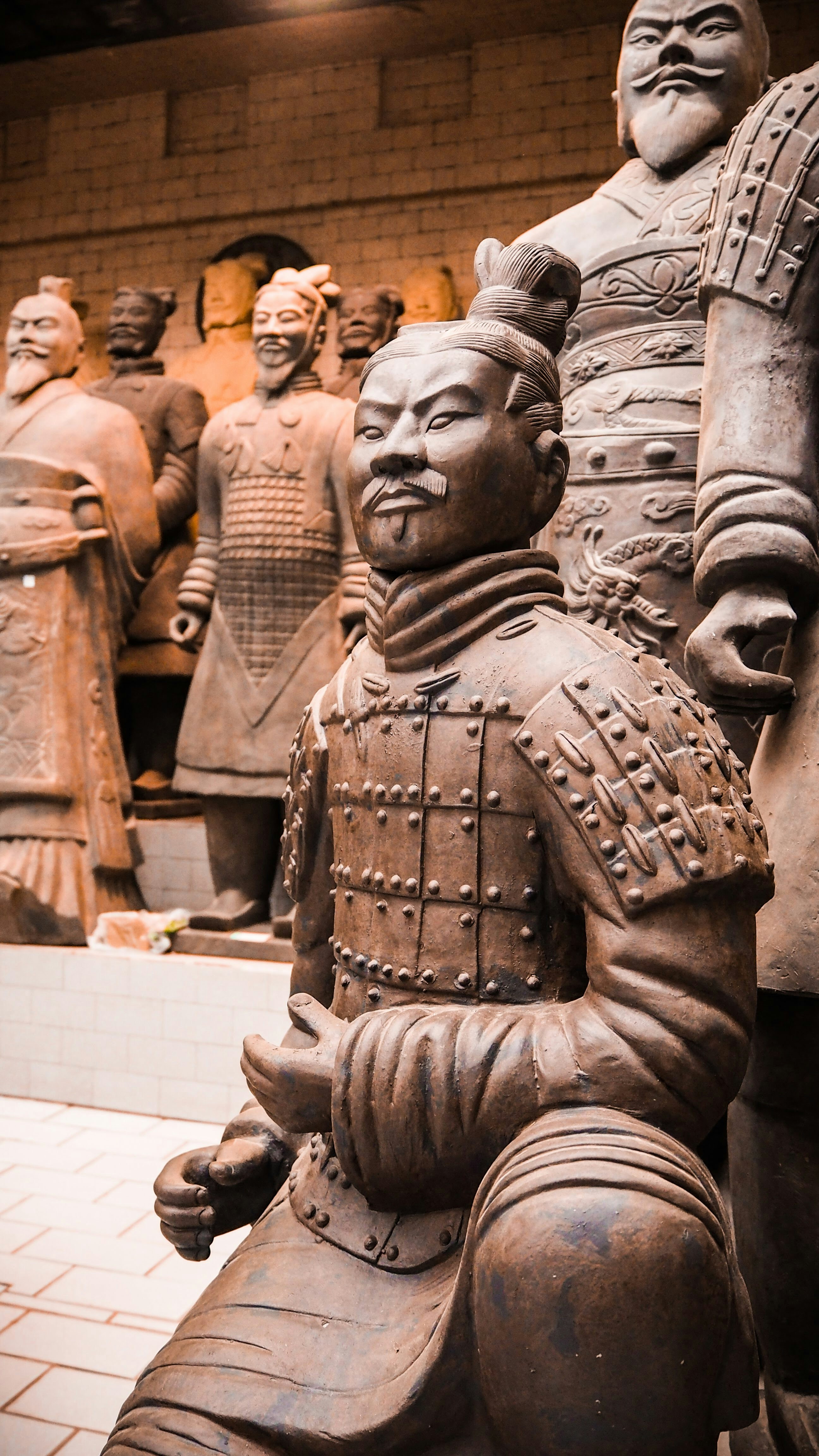 Life-size terracotta warrior soldier statue with detailed facial features and armor, ancient Chinese clay sculpture