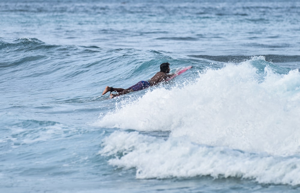 person skimboarding with seawaves during daytime