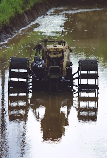 A tractor covered in mud before cleaning in a rural farm setting.