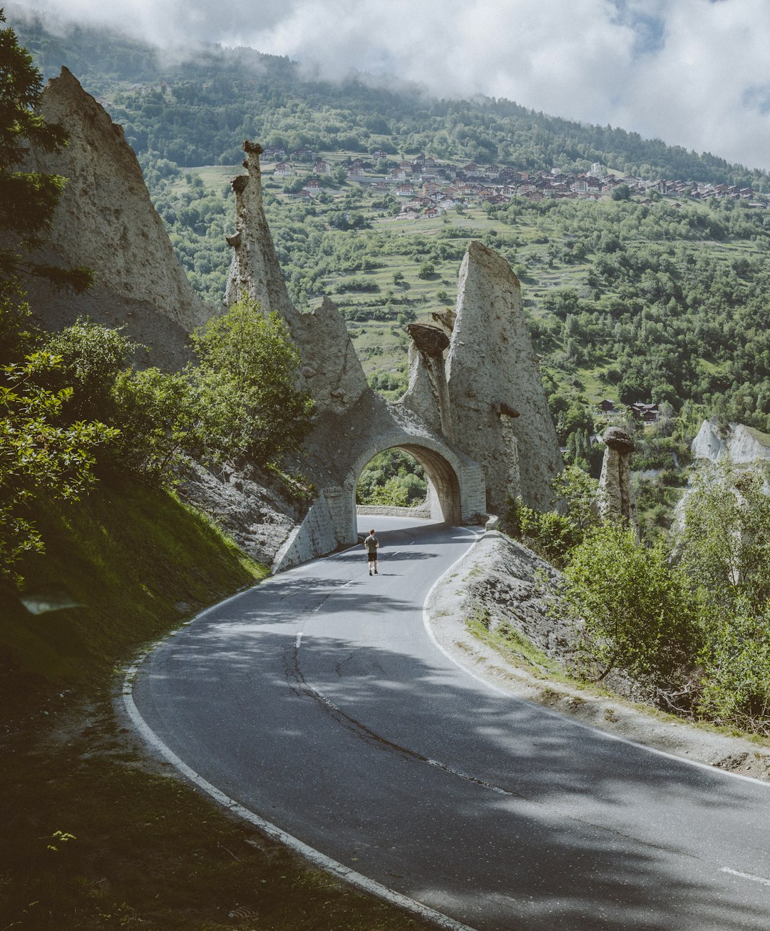 man walking on road near arch