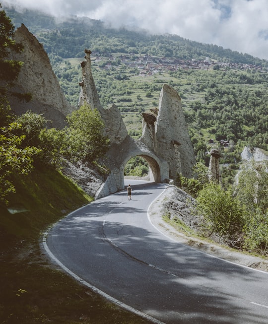 man walking on road near arch in Valais Switzerland