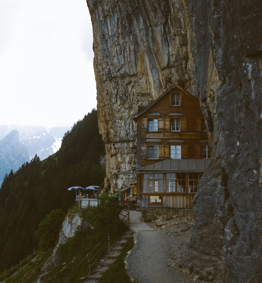 brown wooden house beside cliff