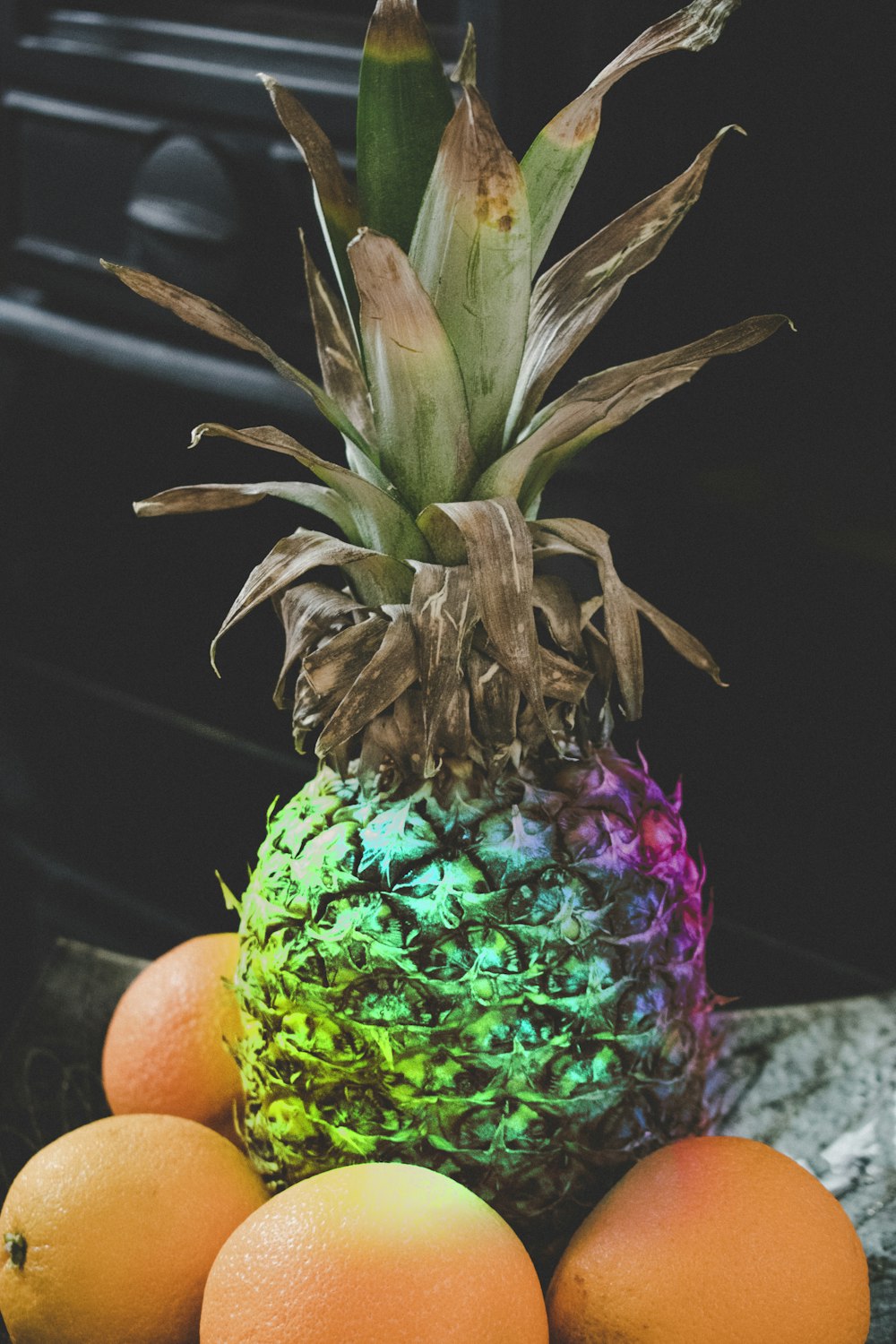 pineapple with four orange fruits