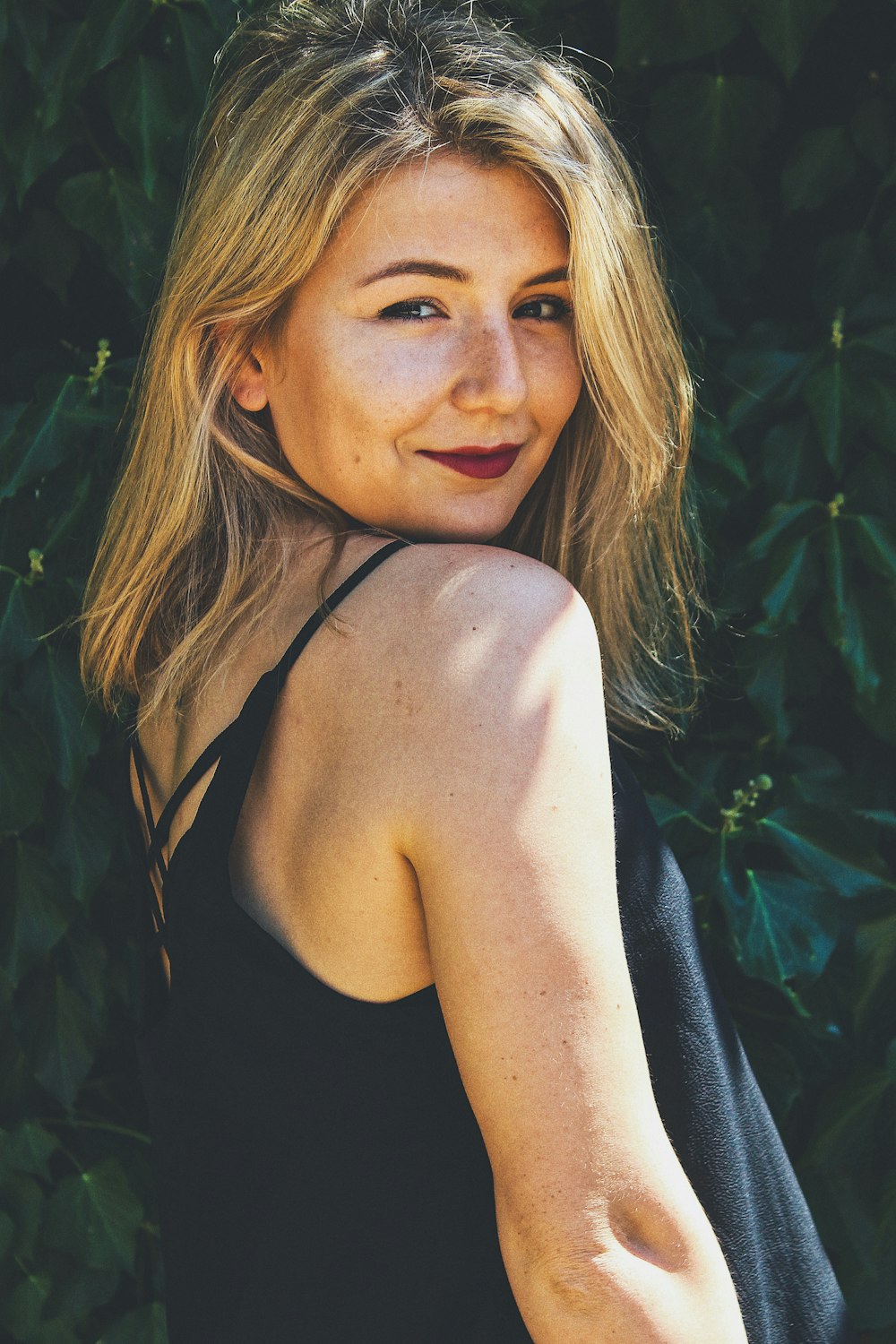 smiling woman wearing black spaghetti strap top