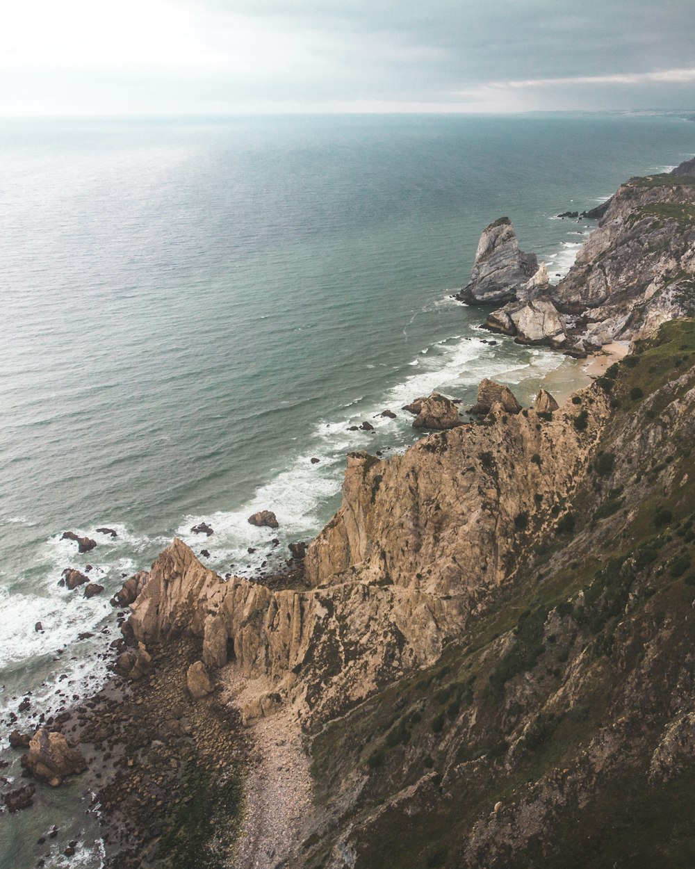 bird's-eye view photo of seashore and cliffs during daytime